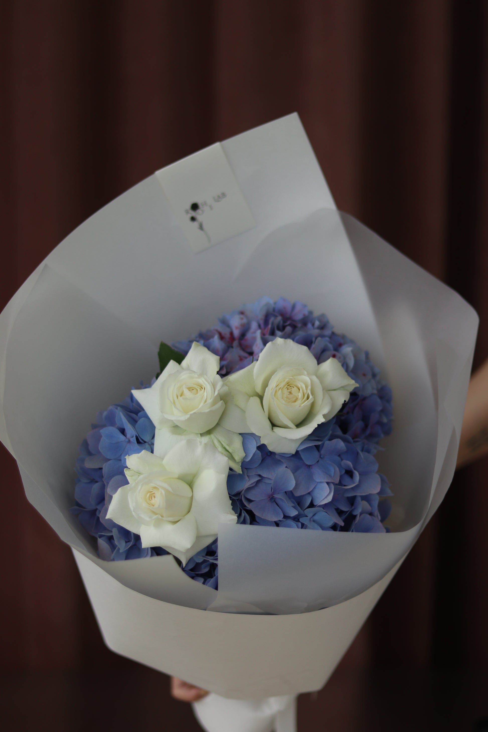 Close-up of Soft Bloom bouquet with soft blue hydrangeas and ivory roses