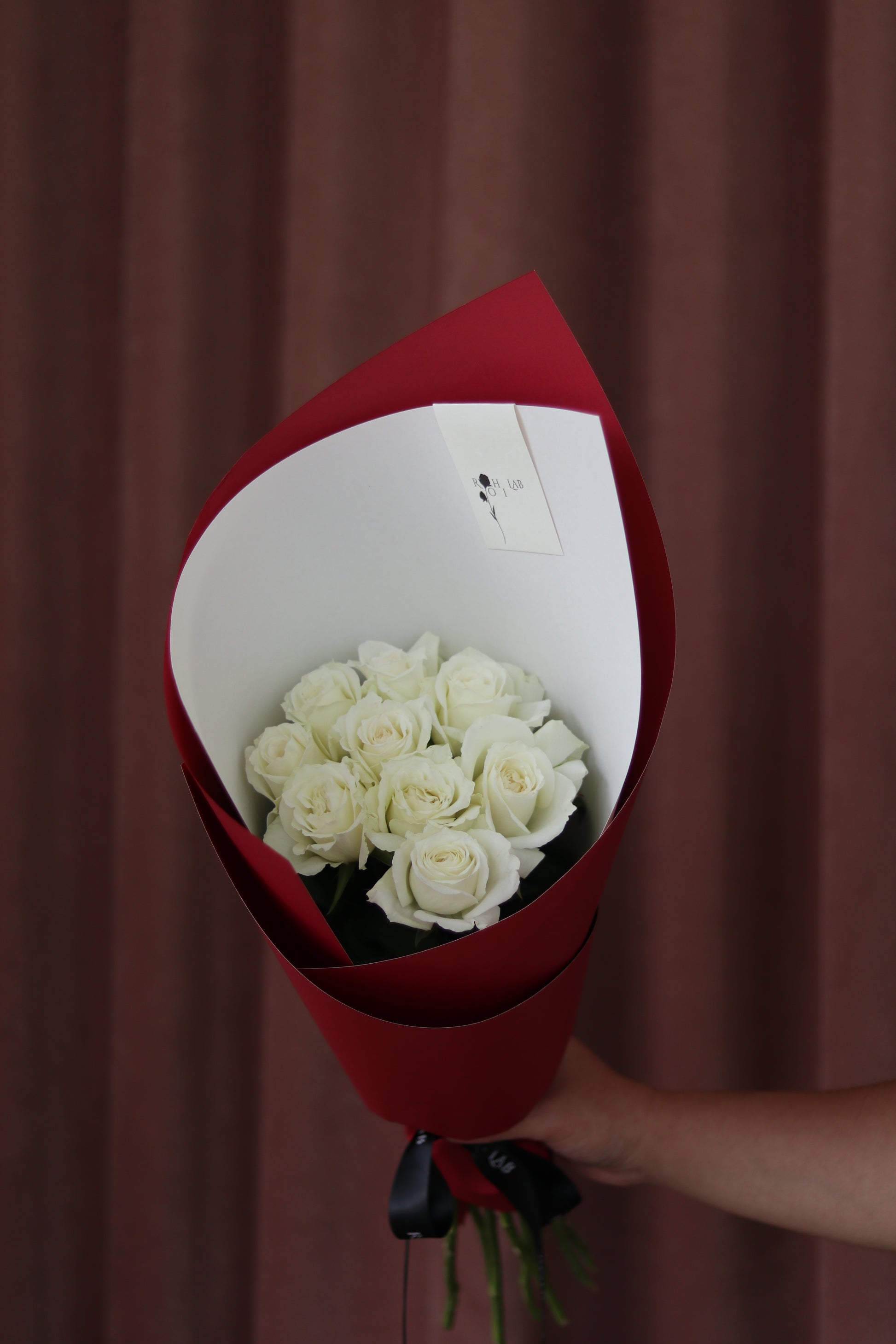 Pure Love white rose bouquet wrapped in signature red paper, hand-tied floral gift by Rōhi Lab Auckland