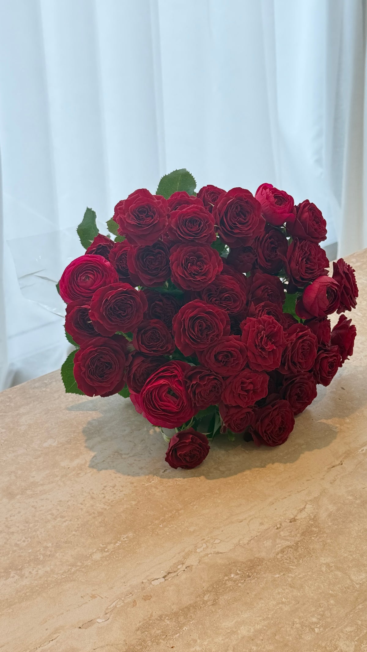 Red spray rose bouquet with clustered blooms arranged for romantic gifting