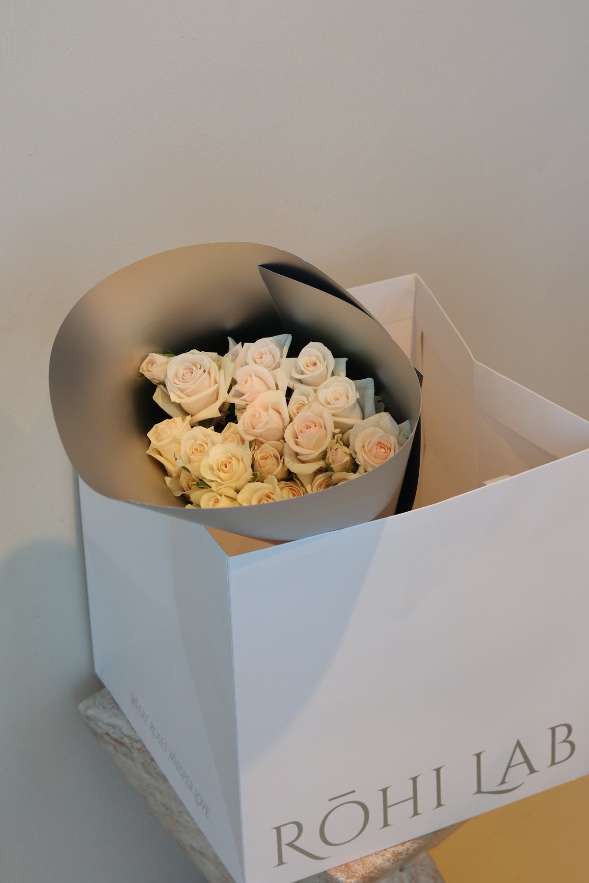 Fresh cream spray rose bouquet wrapped in soft grey paper by Rōhi Lab Auckland