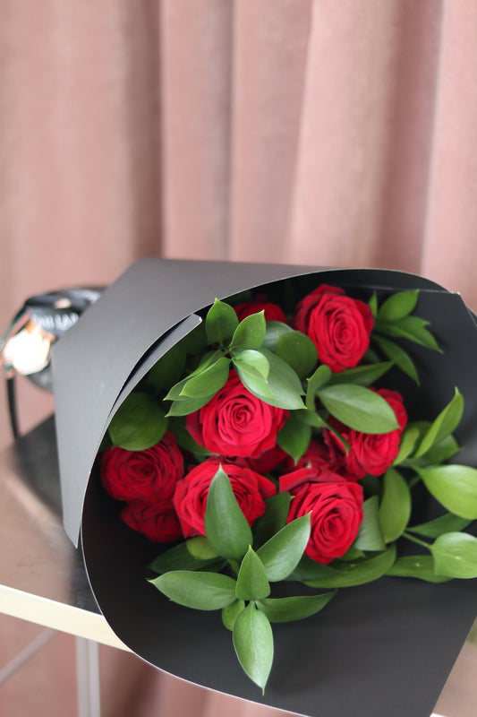Classic red rose bouquet arranged in a traditional round shape, symbolising timeless love and romance
