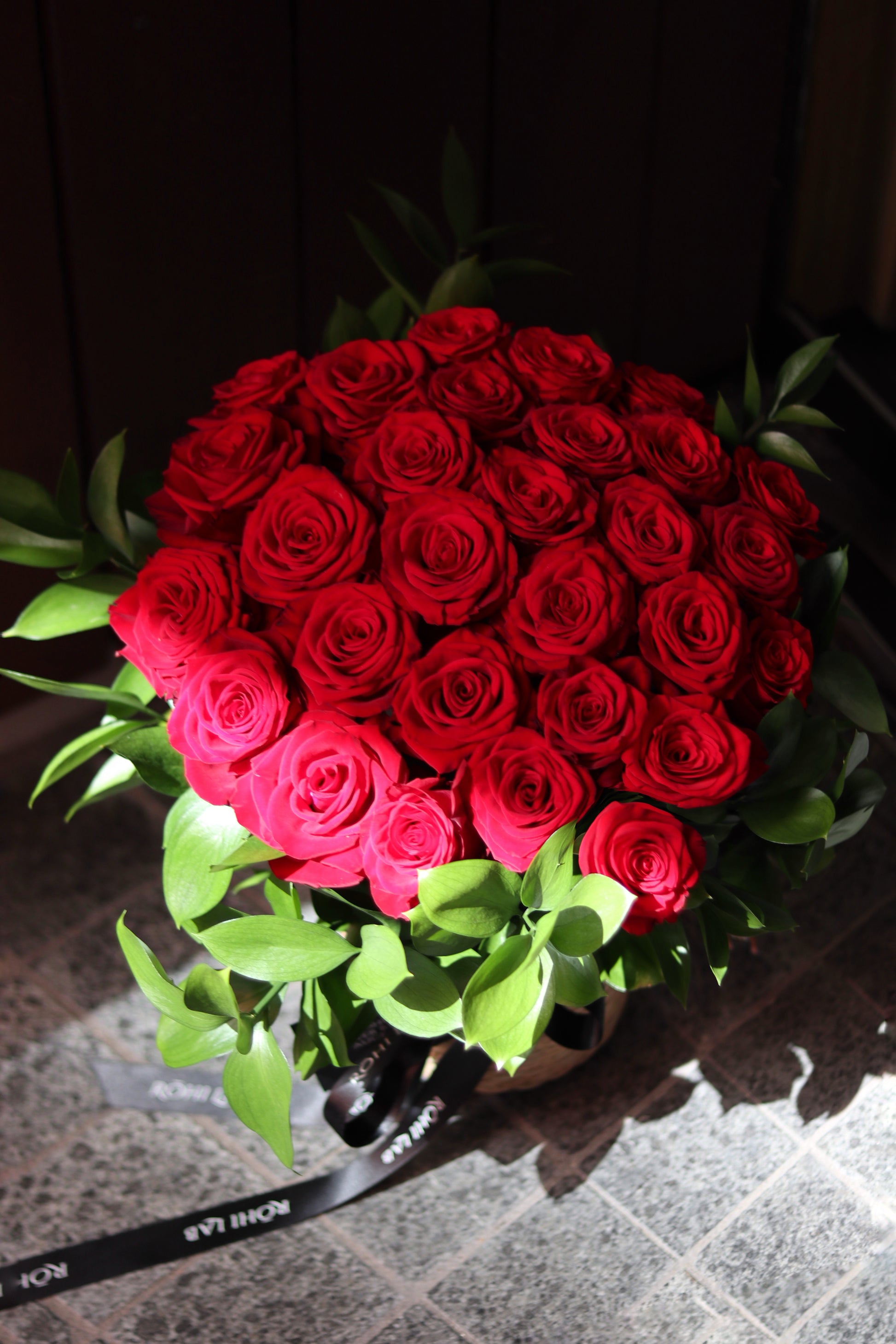 Luxury red rose basket with full round rose arrangement, handcrafted by Auckland florist Rōhi Lab
