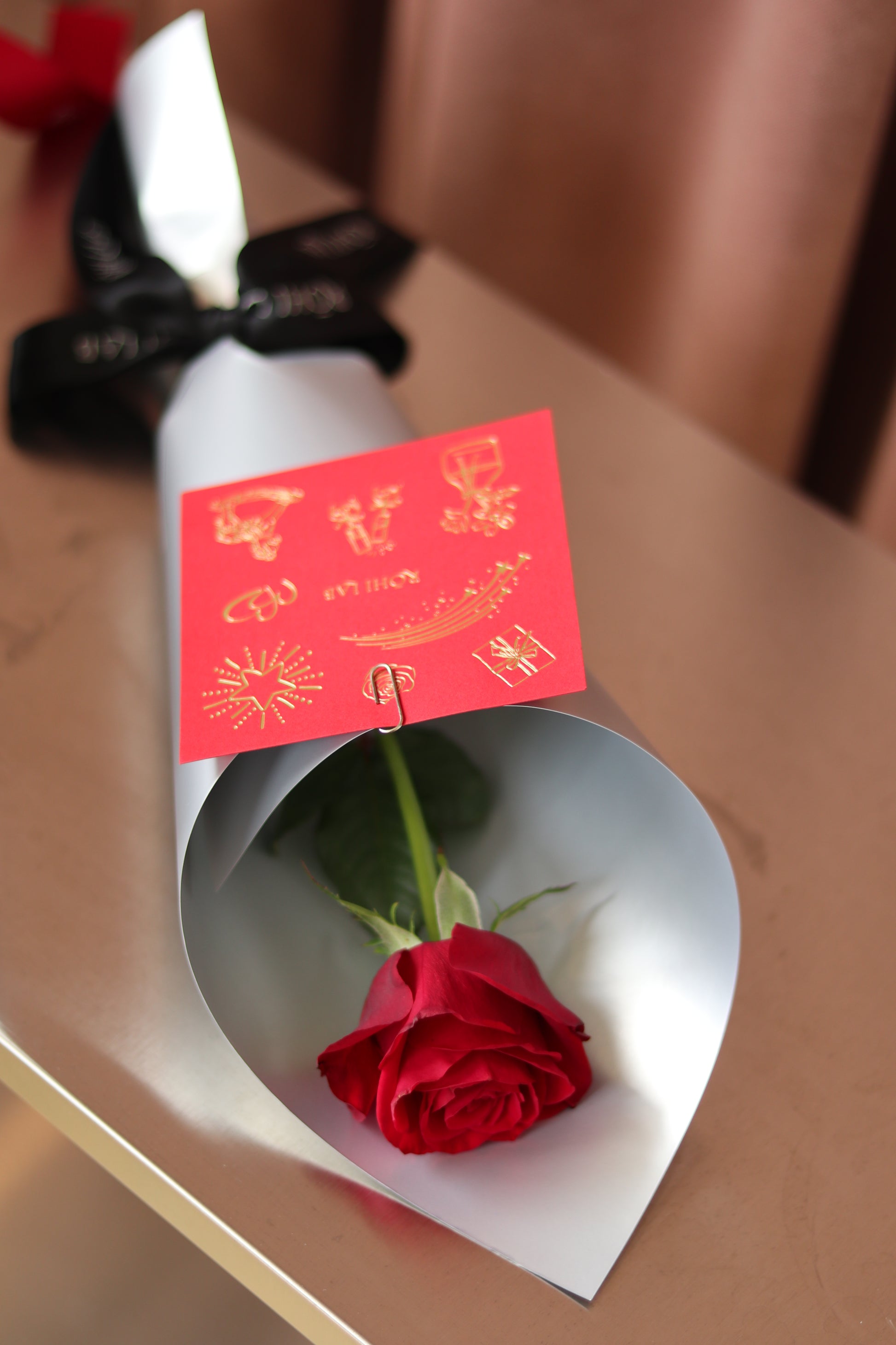 Single red rose wrapped in white paper for Valentine’s Day, Auckland flower