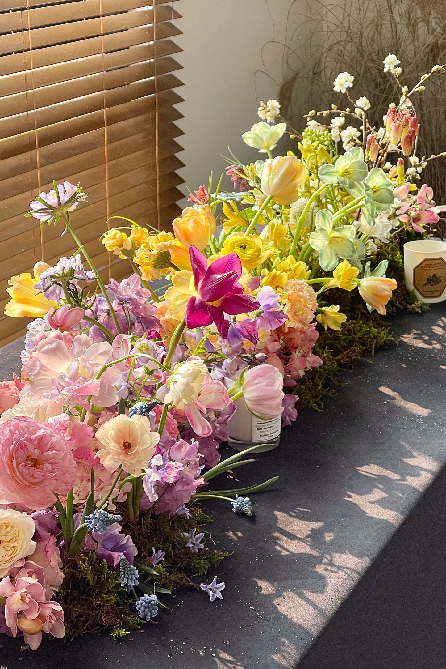 Natural spring floral table installation with pastel flowers styled in sunlight